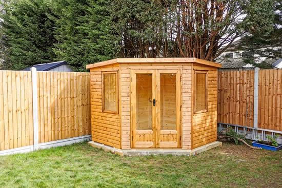 Log cabin installed in a ninety degree garden corner