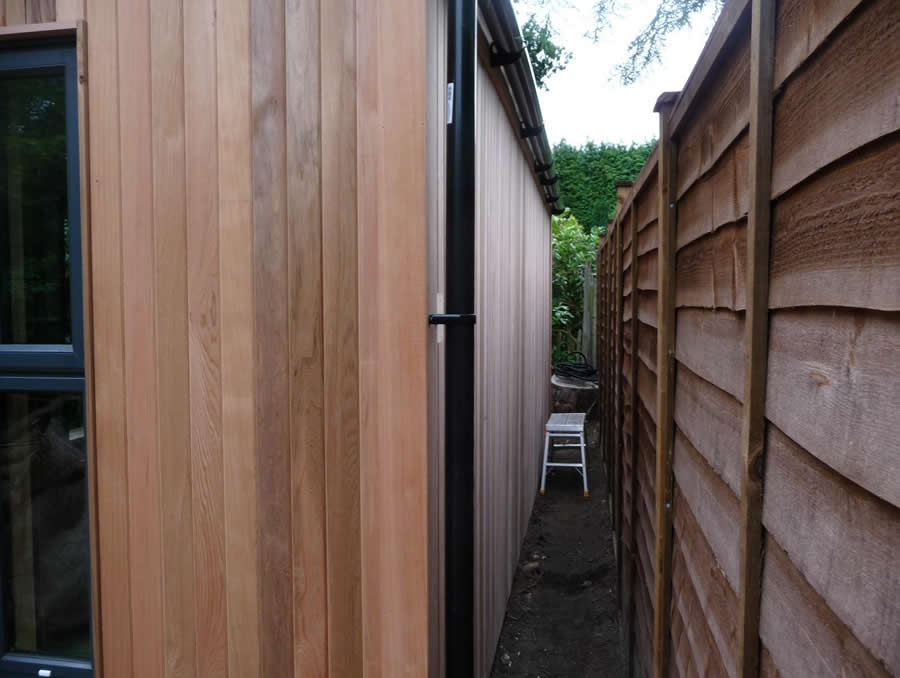 Windowless shed wall positioned close to a boundary fence