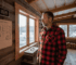 Man checks thermal efficiency inside log cabin