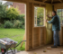 Worker installing insulation in UK garden cabin