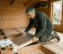 Man installing insulation in garden log cabin