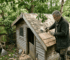 Man installing cedar shingles on cabin roof