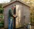 Man checking padlock on garden cabin door