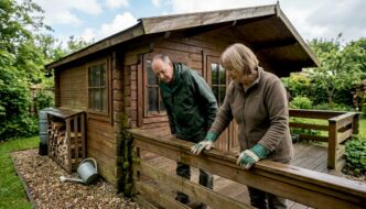 Couple checks a wet garden cabin after rain