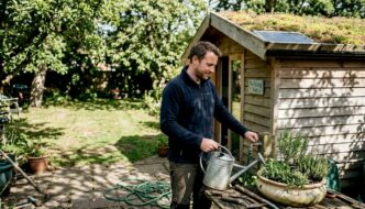 Man tending eco-friendly garden building
