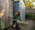 Gardener comparing timber and metal garden sheds